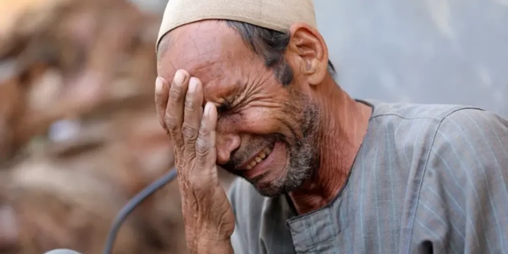 Homem chora no Egito após enterrar o corpo repatriado de seu filho, vítima das enchentes causadas pelos temporais na Líbia