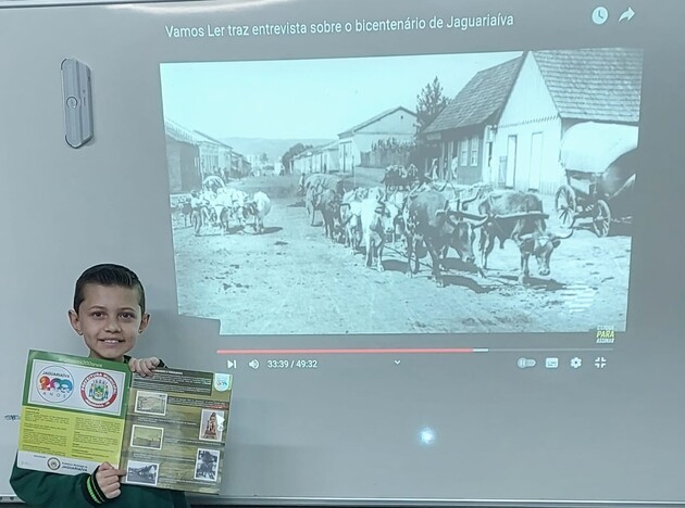 Foto da aula de história com o uso do álbum Jaguariaíva 200 anos - Rua do Comércio, Cidade Alta