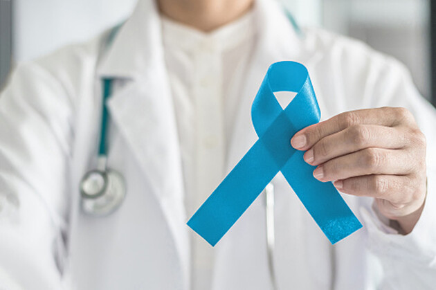 Fita azul simbólica para campanha de conscientização do câncer de próstata e saúde masculina na mão do médico