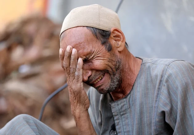 Homem chora no Egito após enterrar o corpo repatriado de seu filho, vítima das enchentes causadas pelos temporais na Líbia