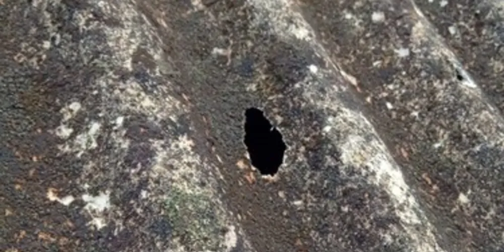 Vários furos como esse estão ao longo do telhado