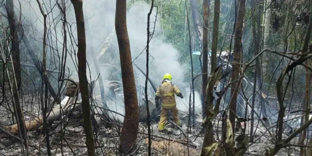 Bombeiro trabalha em meio aos destroços do avião que caiu perto do aeroporto em Rio Branco, após o fogo ser controlado