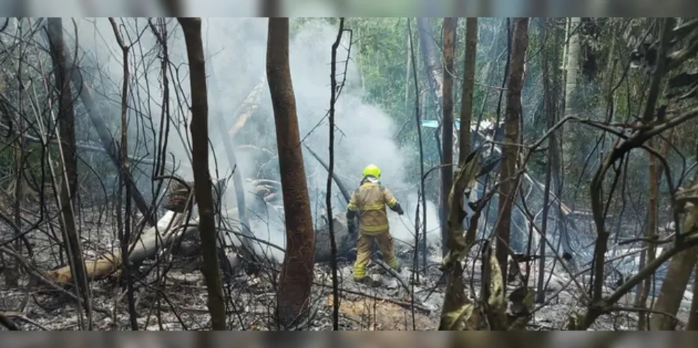 Bombeiro trabalha em meio aos destroços do avião que caiu perto do aeroporto em Rio Branco, após o fogo ser controlado