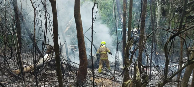 Bombeiro trabalha em meio aos destroços do avião que caiu perto do aeroporto em Rio Branco, após o fogo ser controlado