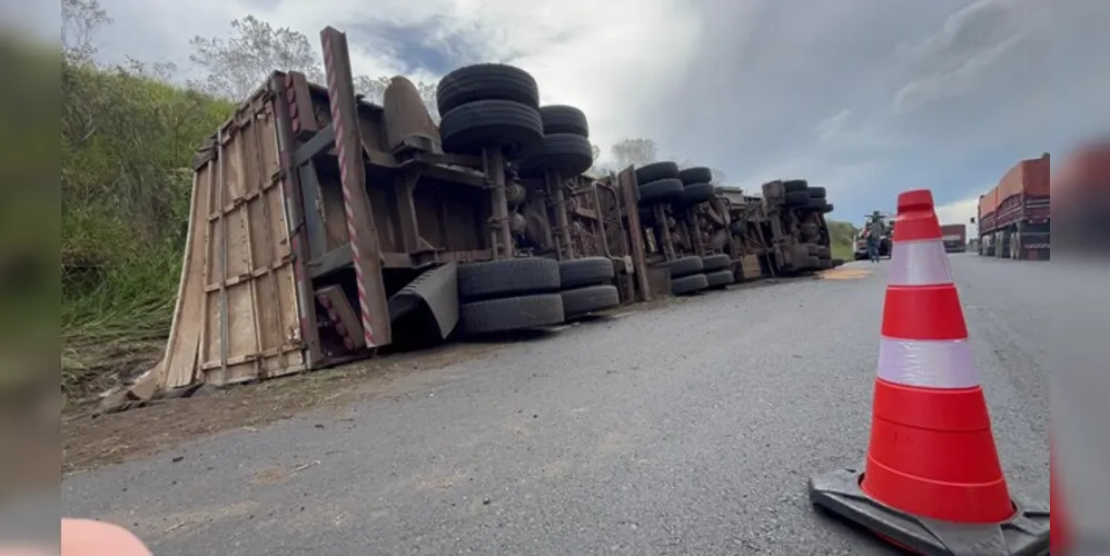 Motorista foi 'fechado' por outro caminhão, tentou desviar e acabou tombando o veículo.