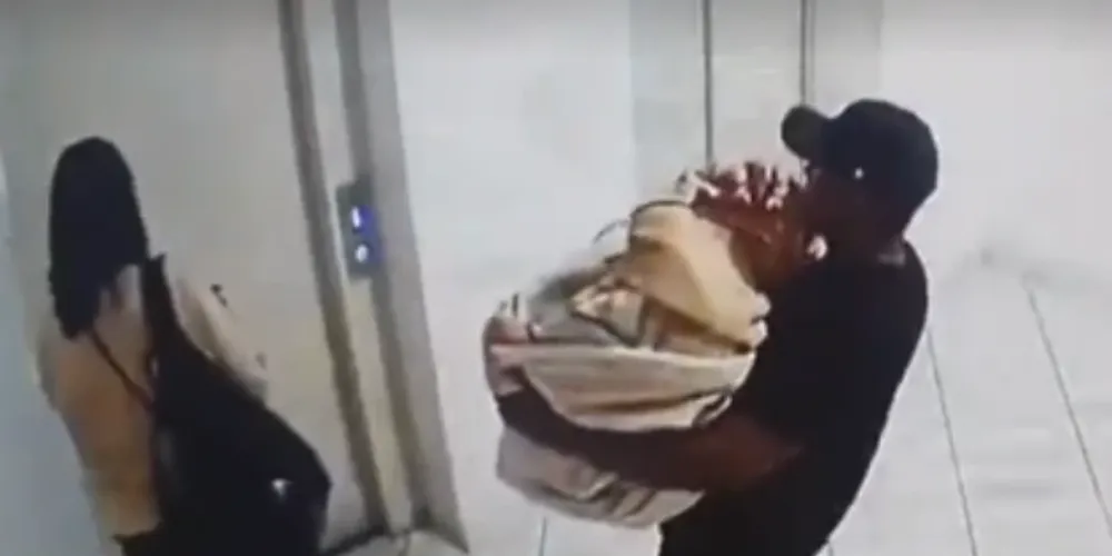 Imagem obtida pela PC mostra casal levando o corpo.