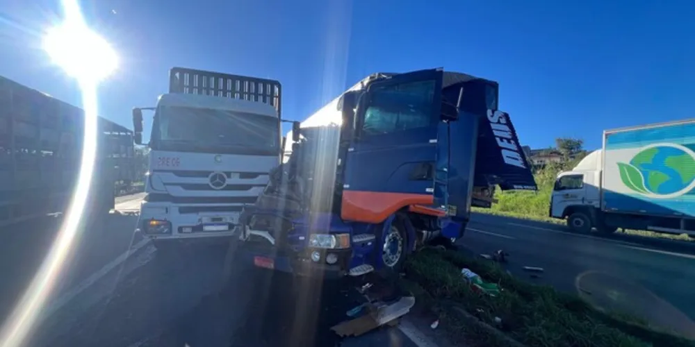 Um carro ficou prensado entre dois caminhões