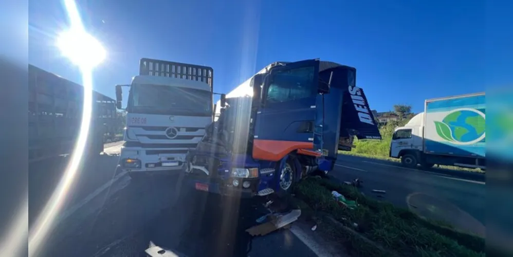 Um carro ficou prensado entre dois caminhões