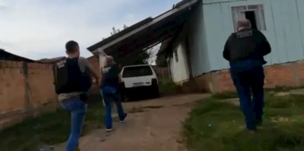 Agentes de segurança em frente à casa de um suspeito