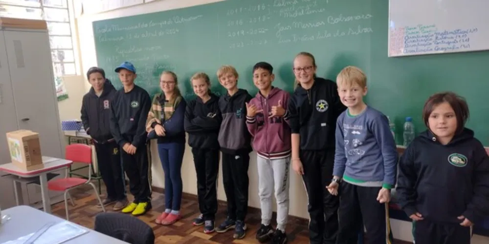 Entusiasmados com a proposta, a turma organizou a sala com a representação de uma urna, alunos na função de mesários e cadernos de votação