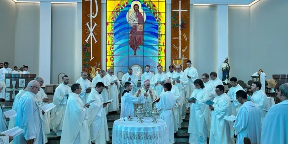 Padres e o bispo rezam juntos na bênção dos santos óleos.
