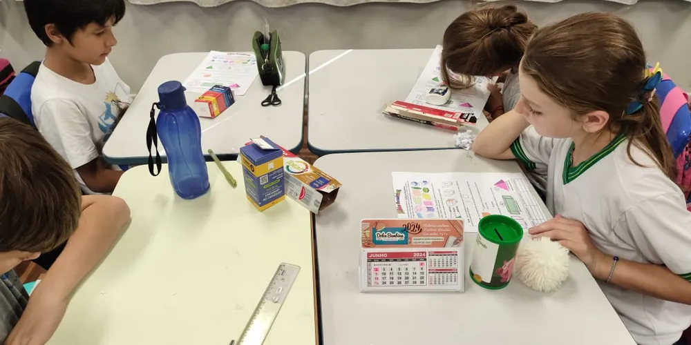 Uma das atividades realizadas pela turma envolveu a montagem de formas geométricas com caixinhas que os estudantes levaram de casa