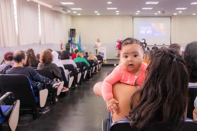 A estudante Hemili Maruim assiste a uma palestra na UEPG  e no seu colo está sua filha, a pequena Melanie.
