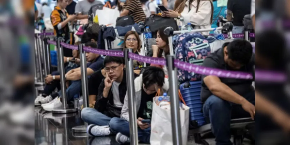 Passageiros esperam para fazer check-in no Aeroporto Internacional de Hong Kong nesta sexta-feira após apagão cibernético