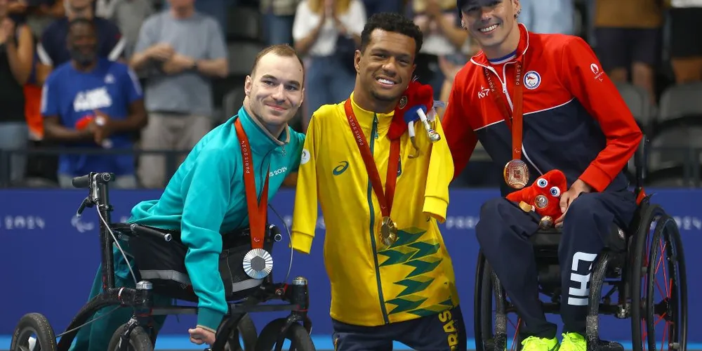 Gabrielzinho com os colegas de pódio dos 50m costas classe S2.