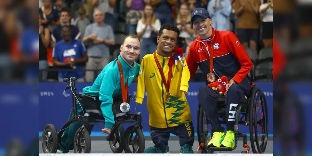 Gabrielzinho com os colegas de pódio dos 50m costas classe S2.