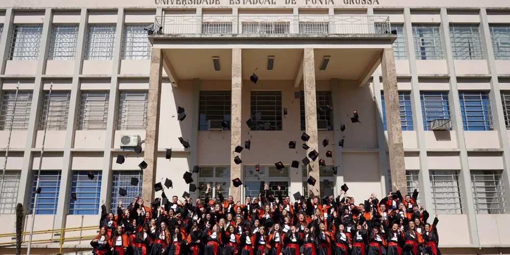 Todos enfileirados na escadaria do Bloco A, cena comum aos formandos.