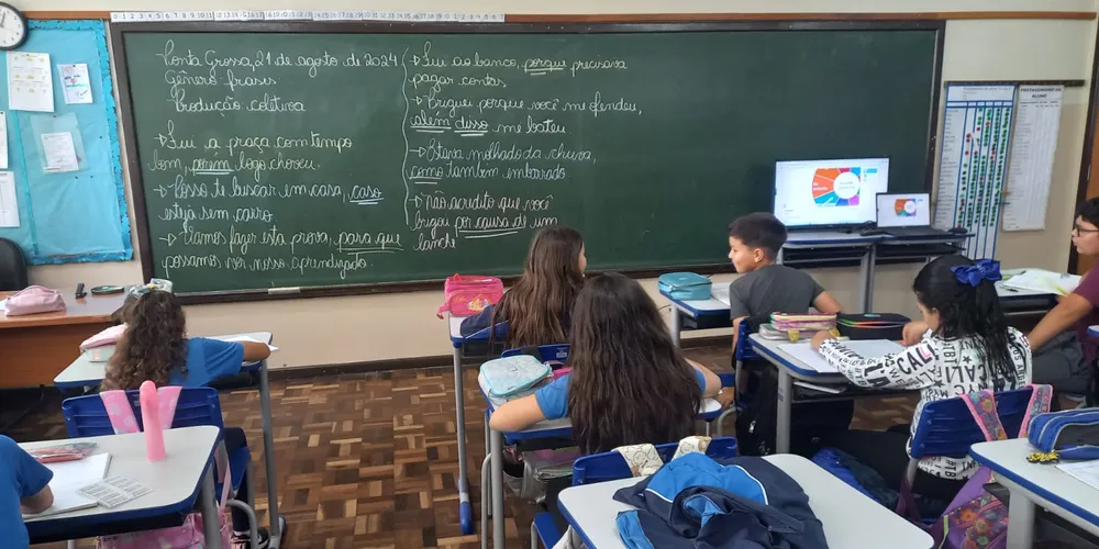 Uma das ações realizadas pela turma envolve a seleção de termos em um computador e a montagem de frases na sequência