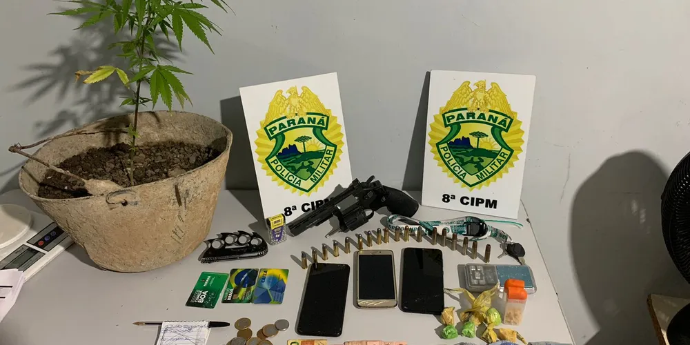 No local, foi encontrado um simulacro de revólver, munições, uma certa quantidade de droga, dinheiro e balança de precisão