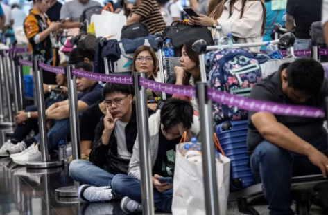 Passageiros esperam para fazer check-in no Aeroporto Internacional de Hong Kong nesta sexta-feira após apagão cibernético