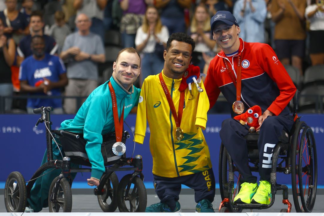 Gabrielzinho com os colegas de pódio dos 50m costas classe S2.