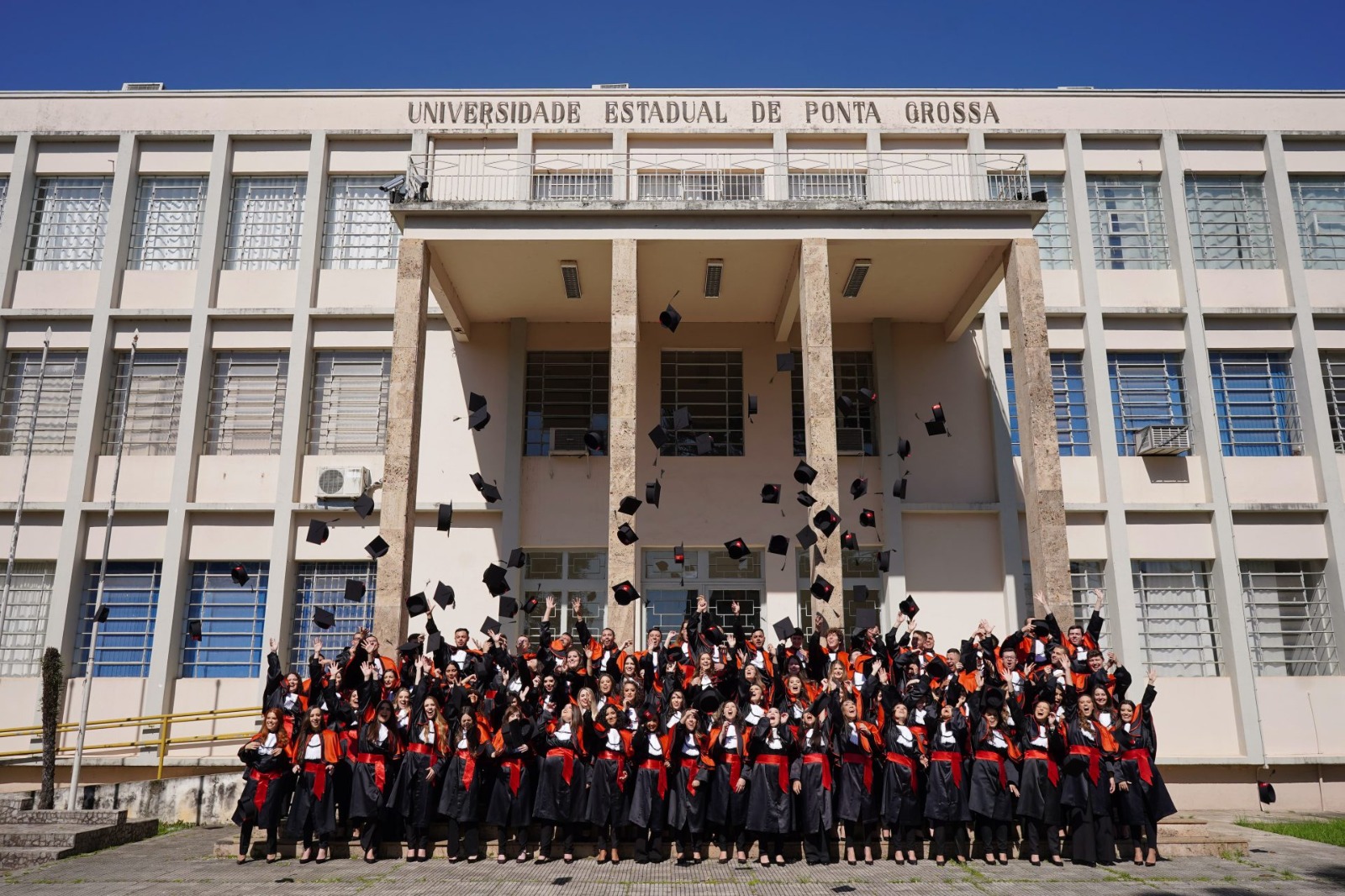 Todos enfileirados na escadaria do Bloco A, cena comum aos formandos.