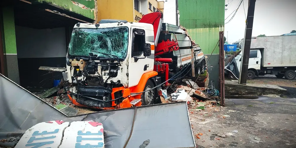 Caminhão ficou danificado após colidir contra os estabelecimentos e carros