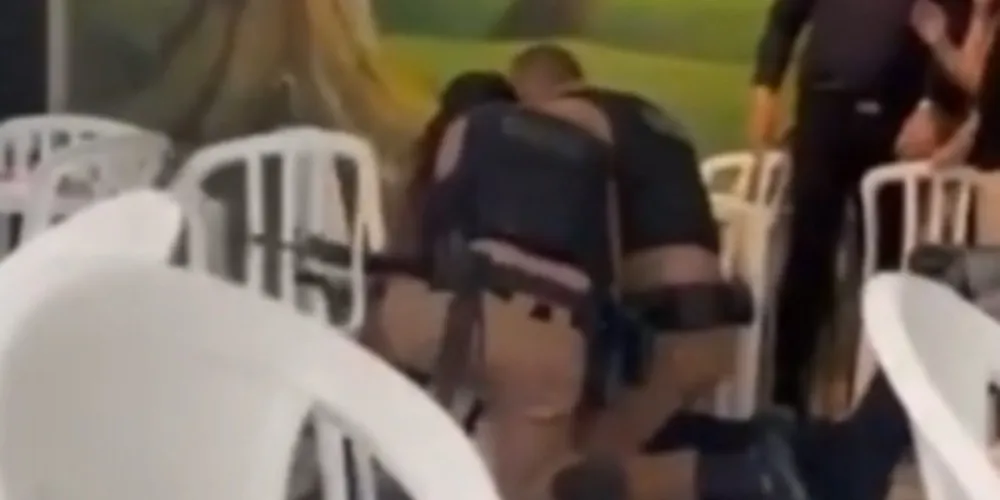 No vídeo, dois agentes da PM aparecem rendendo e imobilizando o suspeito