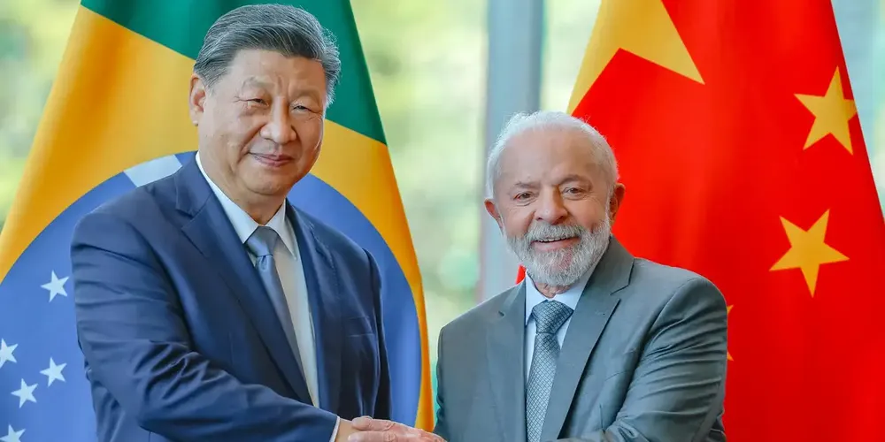 O presidente da China, Xi Jinping, e o presidente do Brasil, Luiz Inácio Lula da Silva, apertam as mãos após assinaturas de acordos bilaterais