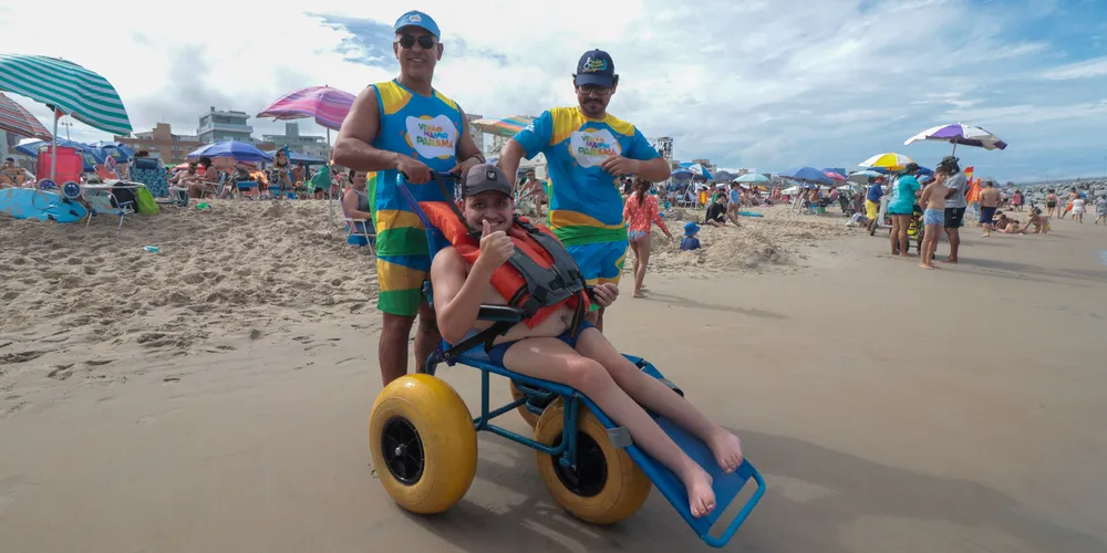 Família passa férias no Litoral do Paraná para filho tomar banho de mar com cadeira anfíbia