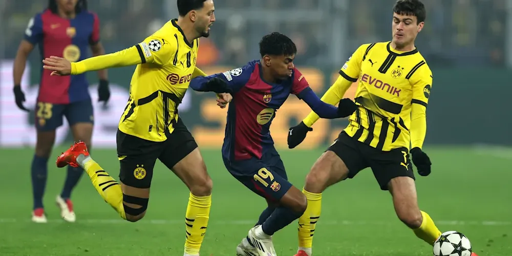 Lamine Yamal driblando dois marcadores do Borussia Dortmund