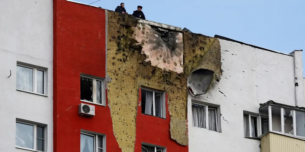 Policiais no telhado de um prédio residencial de vários andares danificado em um recente ataque de drone ucraniano, de acordo com autoridades locais