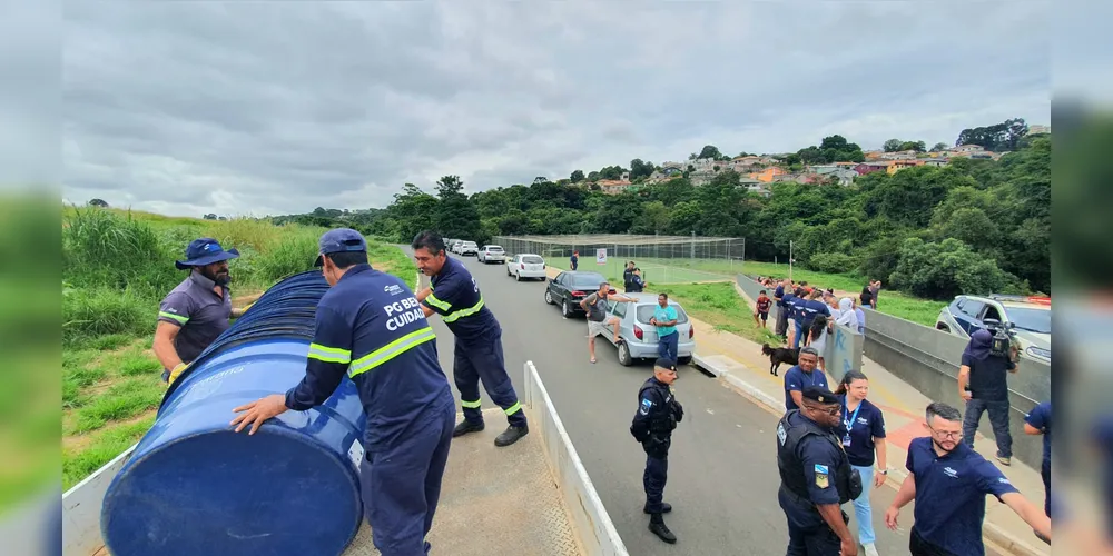 Agentes públicos distribuindo caixas d'água na Vila Nova.