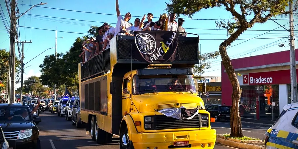 Atletas estão em cima de um caminhão celebrando o título