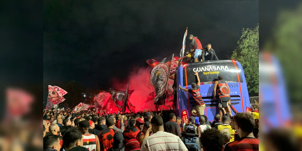 Torcedores do Flamengo sobem em ônibus antes do embarque da equipe no Aeroporto do Galeão (RJ)