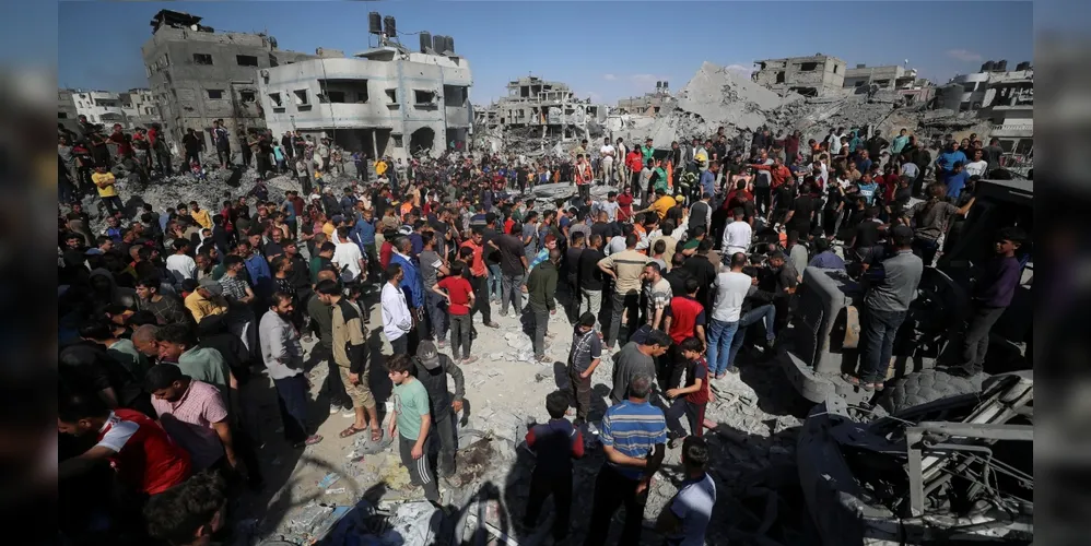 Palestinos procuram vítimas no local de um ataque israelense contra uma casa em Jabalia, no norte da Faixa de Gaza