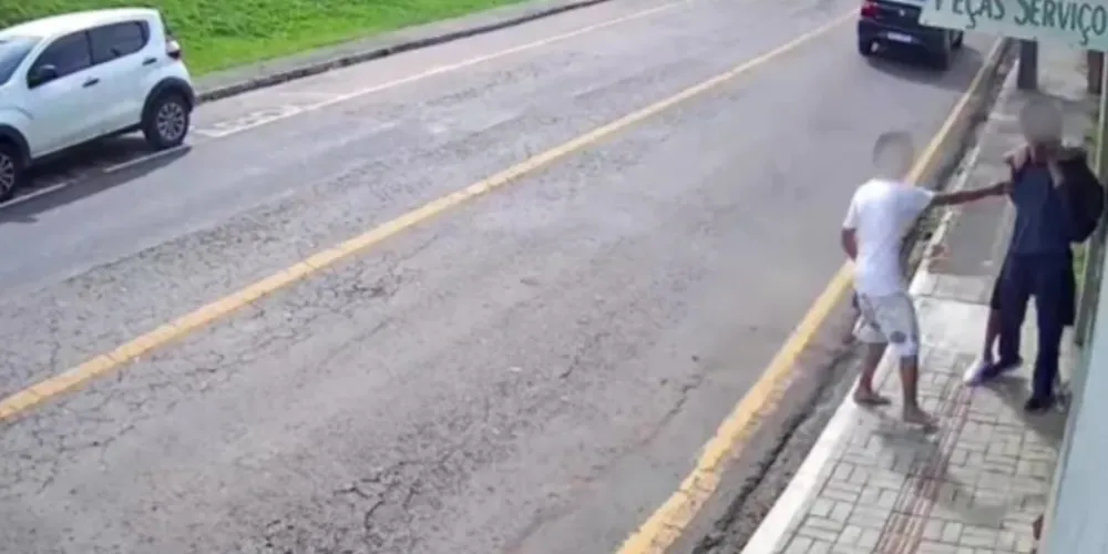 As imagens mostram que um aluno caminhava pela calçada e outras duas pessoas se aproximam