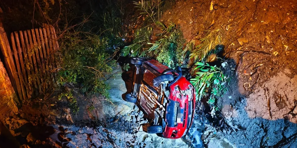 Carro parou tombado ao lado do arroio