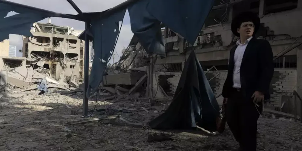 Homem olha cenário destruído após ataque iraniano a Israel