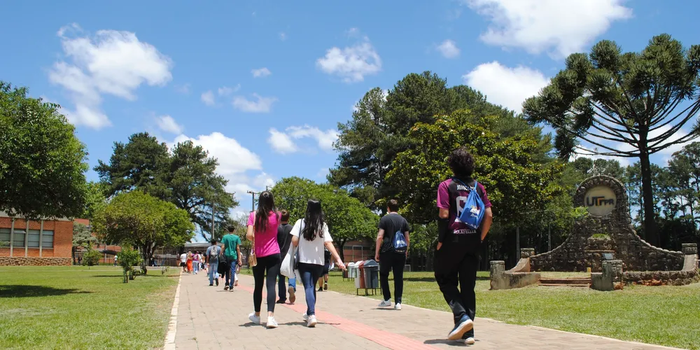 Alunos caminham em campus de universidade