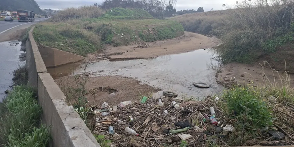 Lixo acumulado no leito do Rio Ronda no entorno da BR-376