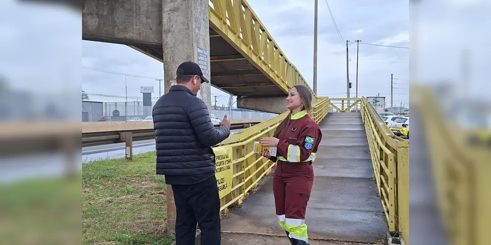 Socorrista da equipe de APH da PRVias orienta pedestre sobre importância de usar a passarela ao atravessar a rodovia na PR-445 em Londrina