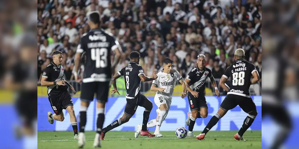 Savarino, meia do Botafogo, tentando escapar da marcação vascaína