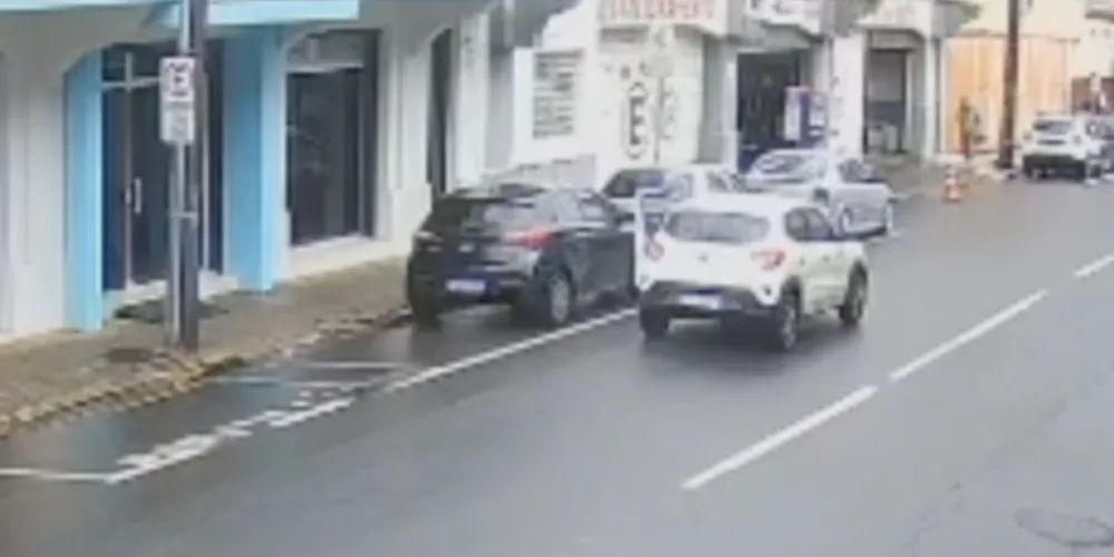 Carro estaciona na rua para pegar relógio caído no chão