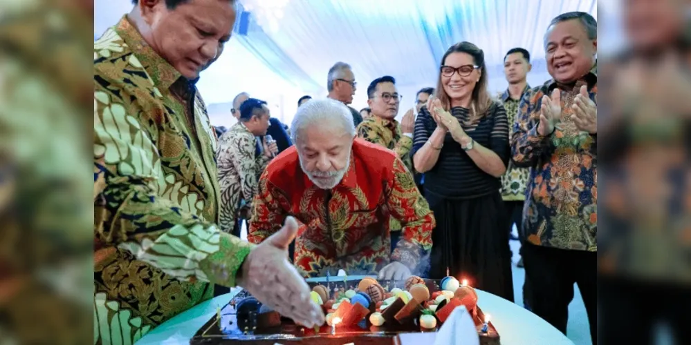 Presidente Lula assoprando as velas de seu bolo de aniversário