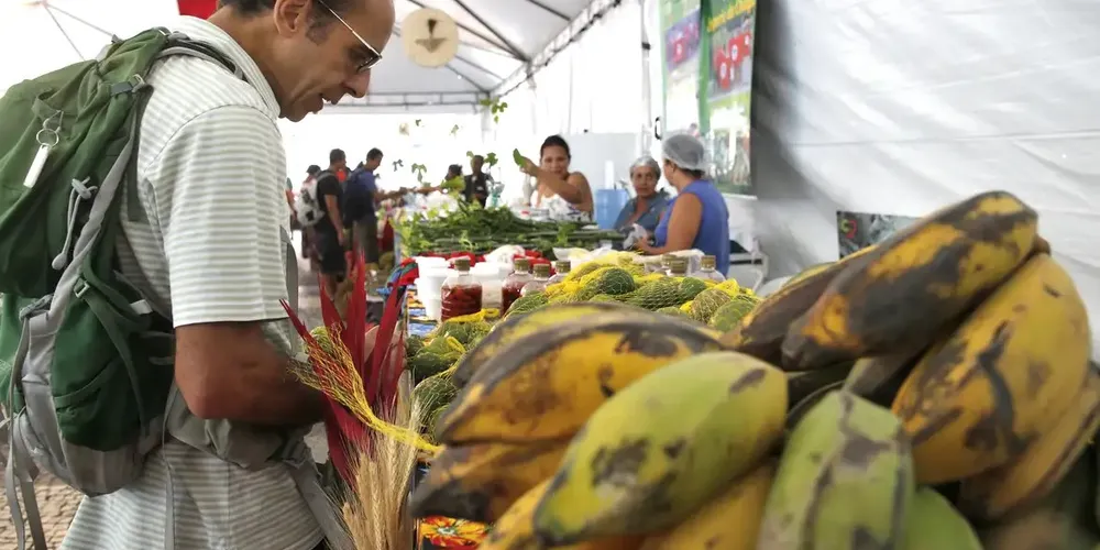 Consumidor escolhendo mercadoria em feira.