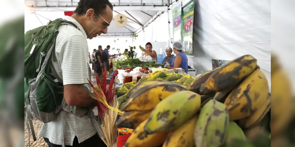 Consumidor escolhendo mercadoria em feira.