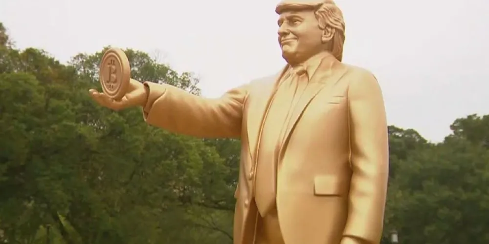 Estátua dourada de Donald Trump segurando um Bitcoin