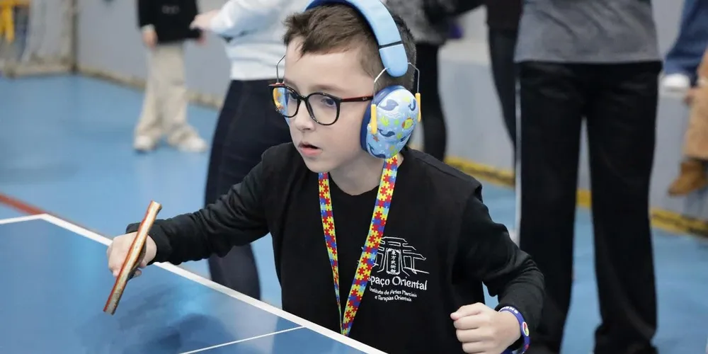 Menino diagnosticado com TEA praticando tênis de mesa