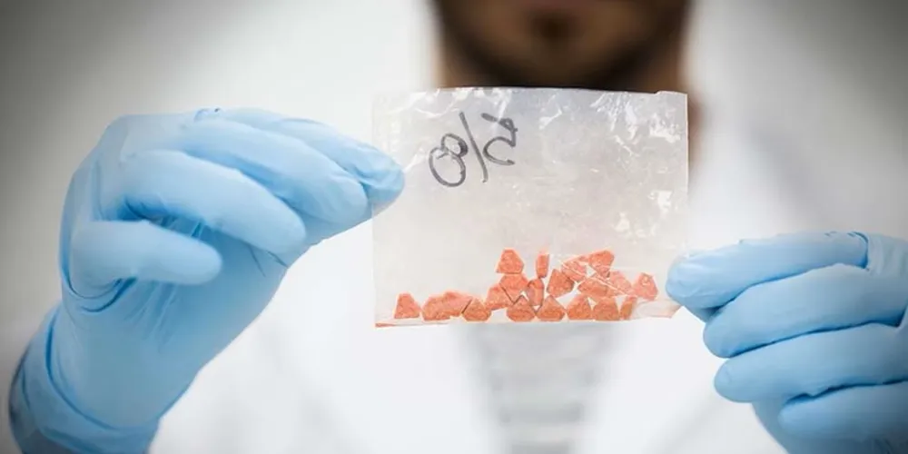 Homem segurando material análogo à droga